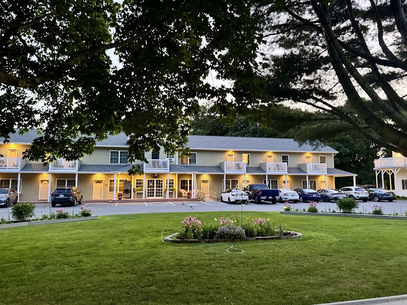 Exterior view of a lodging building with a parking lot and manicured lawn in Acadia National Park, Bar Harbor.
