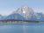 Yellowstone Lake shoreline with a snow-dusted mountain across the water in Yellowstone National Park.