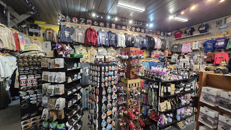 Interior of a Yellowstone National Park gift shop with shelves of magnets, patches, hats, and T-shirts displayed along walls.