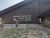 Wooden lodge-style visitor center with a sloped roof and stone edging, at Badlands National Park.