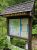 Dead River Trailhead at Acadia National Park's Great Pond Mountain Wildlands, a wooden information board amid green pines.
