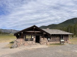 Fishing Bridge Visitor Center sits beside open plains with a stone-and-wood façade in Yellowstone National Park.