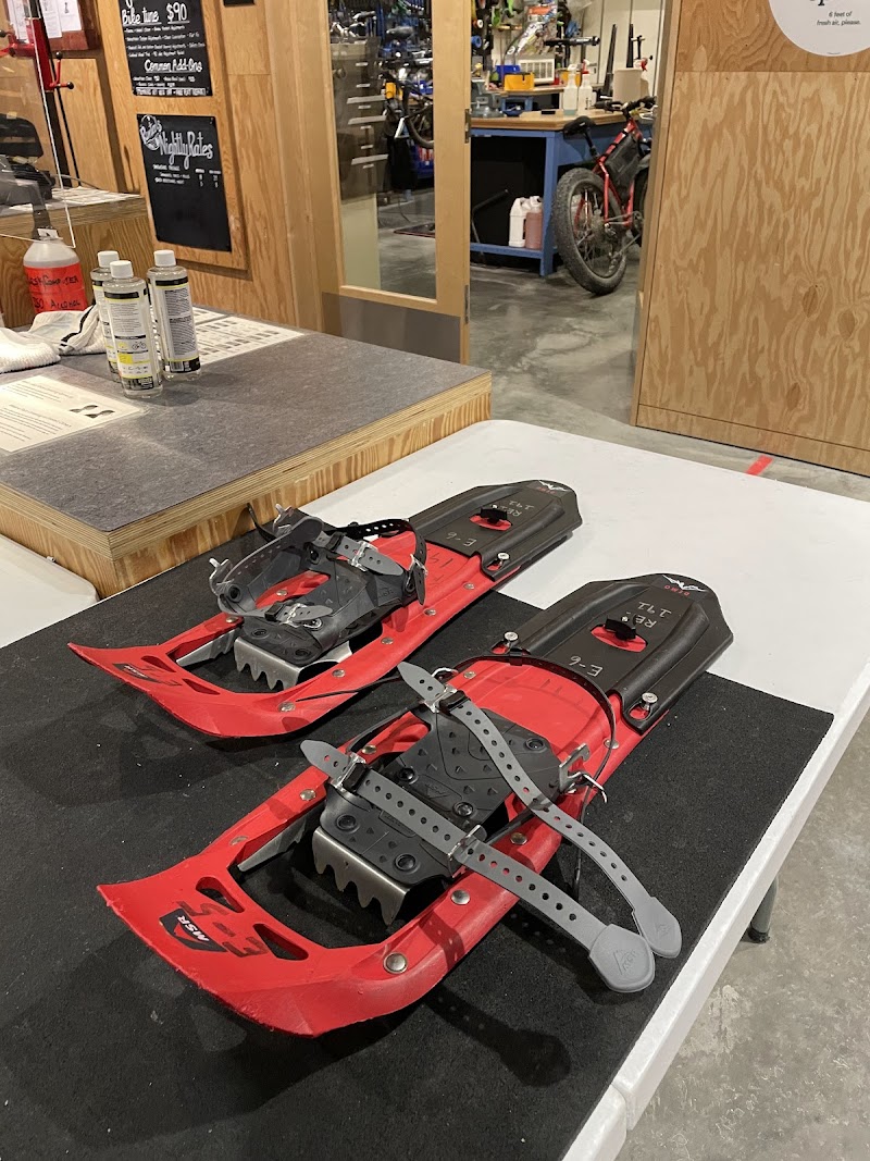 Snowshoe gear display inside a Glacier National Park gift shop, featuring red snowshoes and metal bindings.