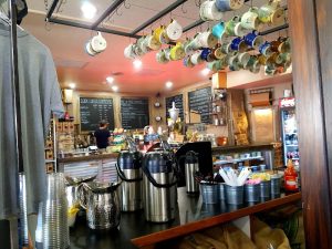 Cafe interior in Yellowstone National Park featuring hanging mugs and stainless coffee dispensers.