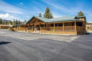Exterior view of a KOA campground entrance with pine trees and RV pads