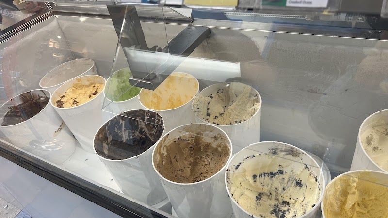 Inside a glass display case at Acadia National Park, a row of white tubs holds assorted ice creams and fudge with colorful swirls.