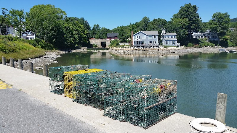 Blue Hill harbor lobster traps line a calm Acadia National Park shoreline at low tide.