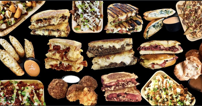 Assorted sandwiches, croissants, sliders and sides arranged on a black background, evoking Acadia National Park dining.