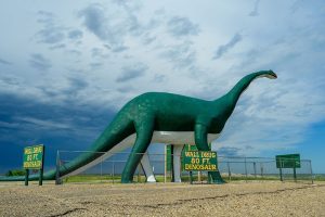 Exterior view of a quaint motel with a neon sign and striped awning