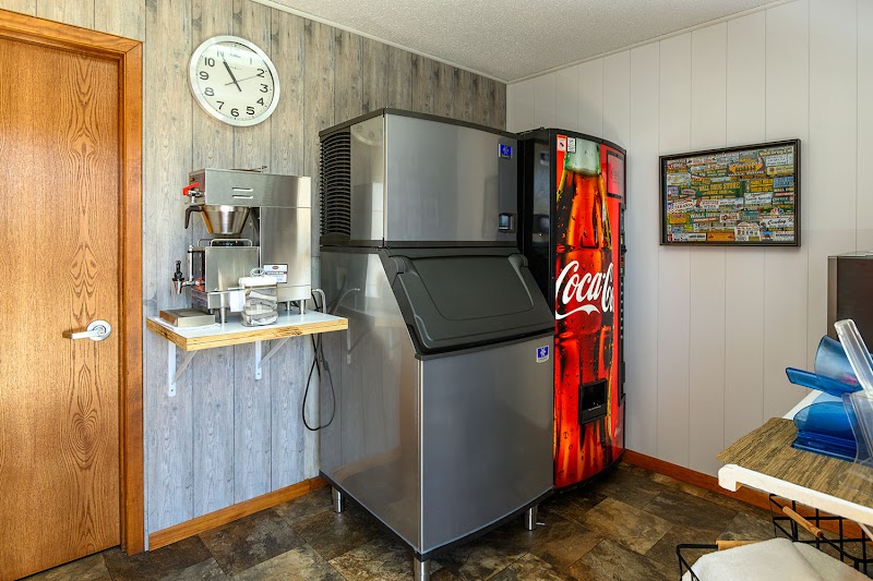 Break room in Badlands National Park with a stainless ice machine, espresso maker, Coca-Cola vending machine, clock, and doorway.