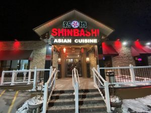 Night view of an Asian cuisine restaurant entrance in Acadia National Park, illuminated signage and red accents along the facade.