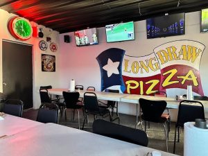 Interior of a casual eatery inside Big Bend National Park featuring a mural and sports TVs.