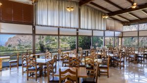 Chisos Mountains Lodge Restaurant interior with large windows framing Big Bend National Park’s rugged canyon and desert views.