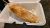 Breaded, fried corn on a stick with a crispy coating rests in a white takeout container at Arches National Park.
