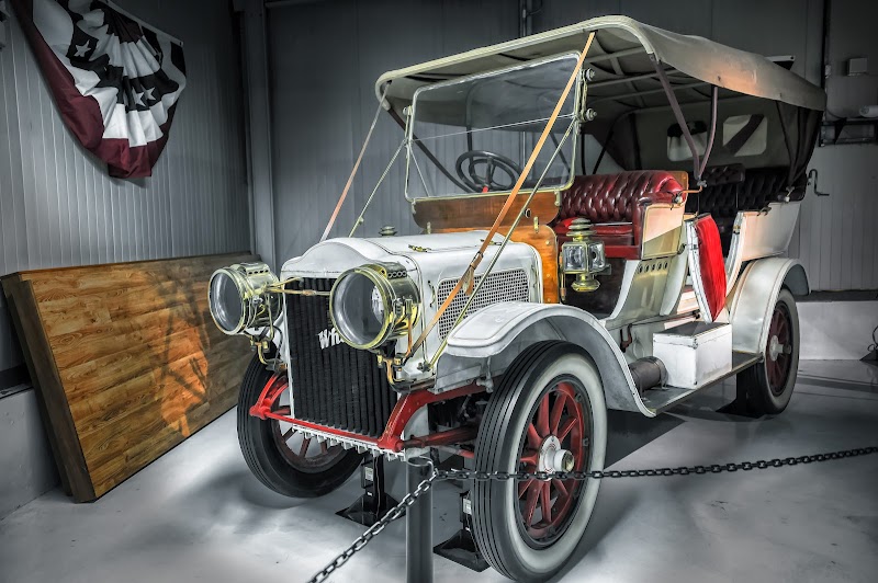Antique automobile on display inside Acadia National Park Visitor Center, with vintage lighting and seating nearby.