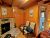 Interior of a Yellowstone lodge lobby with a stone fireplace, warm wood paneling, and doorway to a bathroom.