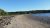 Sedgwick Beach along Acadia National Park's coastline, with sandy shore, rocks, and pine trees in the distance.