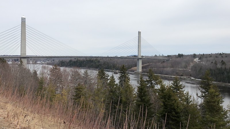 Prospect bridge over a river with forested banks and distant shoreline in Acadia National Park.