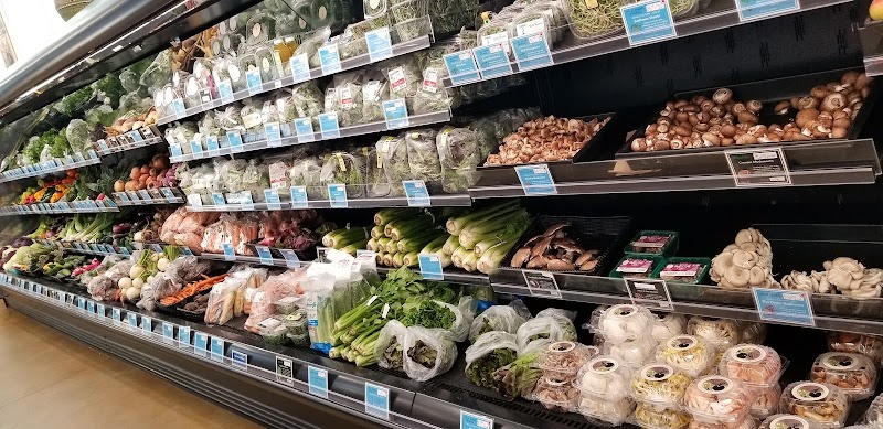 Produce section inside a community co-op in Acadia National Park, featuring shelves of greens, mushrooms, and other produce.