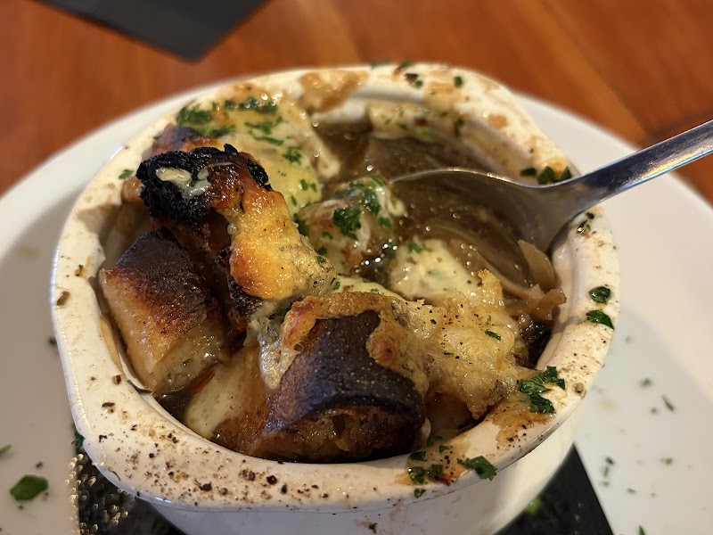 Creamy soup with large crusty croutons, herbs, and a silver spoon in a white bowl at Acadia National Park.