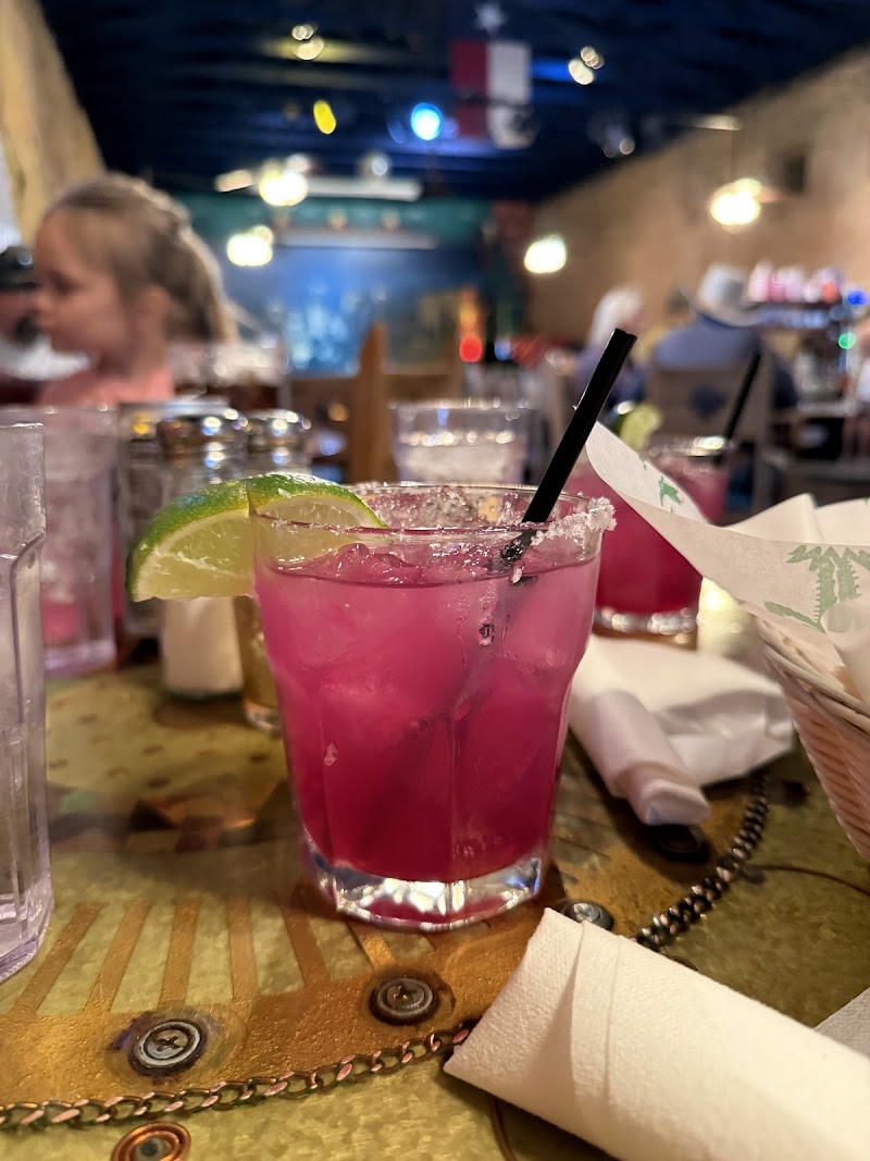 Theatre interior at Big Bend National Park featuring a bright pink cocktail with lime on a table.