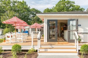 Outdoor deck at Acadia National Park lodging with striped red and white umbrellas and seating.