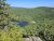 Echo Lake Beach in Acadia National Park, a blue lake edged by dense pines with a rocky overlook under a clear sky.