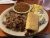 Dreamwood Hill in Acadia National Park serves a hearty pulled pork platter with beans, cornbread, and sides on a round plate.