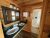 Wood-paneled bathroom with a black-framed mirror, double sinks on a green counter, and towels in Badlands National Park.