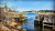 Corea harbor lobster traps line the shoreline at Acadia National Park, with rocky foreground and calm blue water.