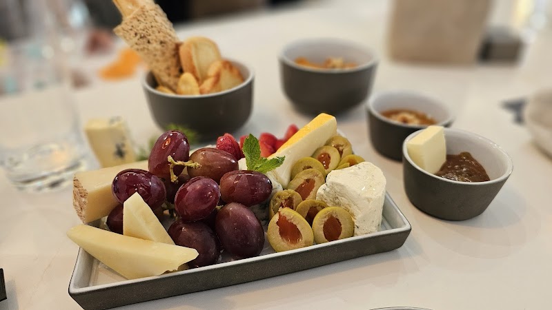 Charcuterie tray with red grapes, cheese wedges, olives, breadsticks, and small bowls of dips at Arches National Park.