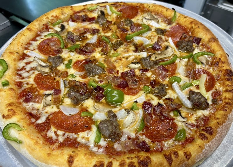 Large pepperoni and veggie pizza on a metal tray, topped with mushrooms, peppers, onions, and sausage in Acadia National Park.