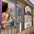 Smiling barista leans from a rustic shack window, holding a cup beside a chalkboard menu at Arches National Park.