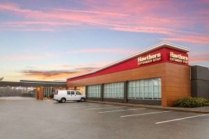 Extended stay hotel exterior in Ellsworth near Bar Harbor, Acadia National Park, showing sunset over a modern lodging building.