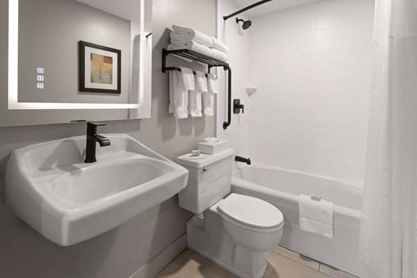 Guest bathroom in Bar Harbor lodging near Acadia National Park, featuring a modern sink, toilet, and tub/shower.