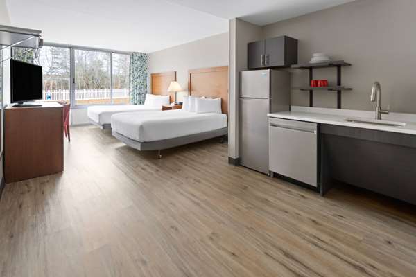 Extended-stay hotel room in Acadia National Park with two beds, kitchenette, and modern furnishings.