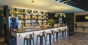 Interior view of a modern Yellowstone National Park bar and dining area with a long counter and stools.