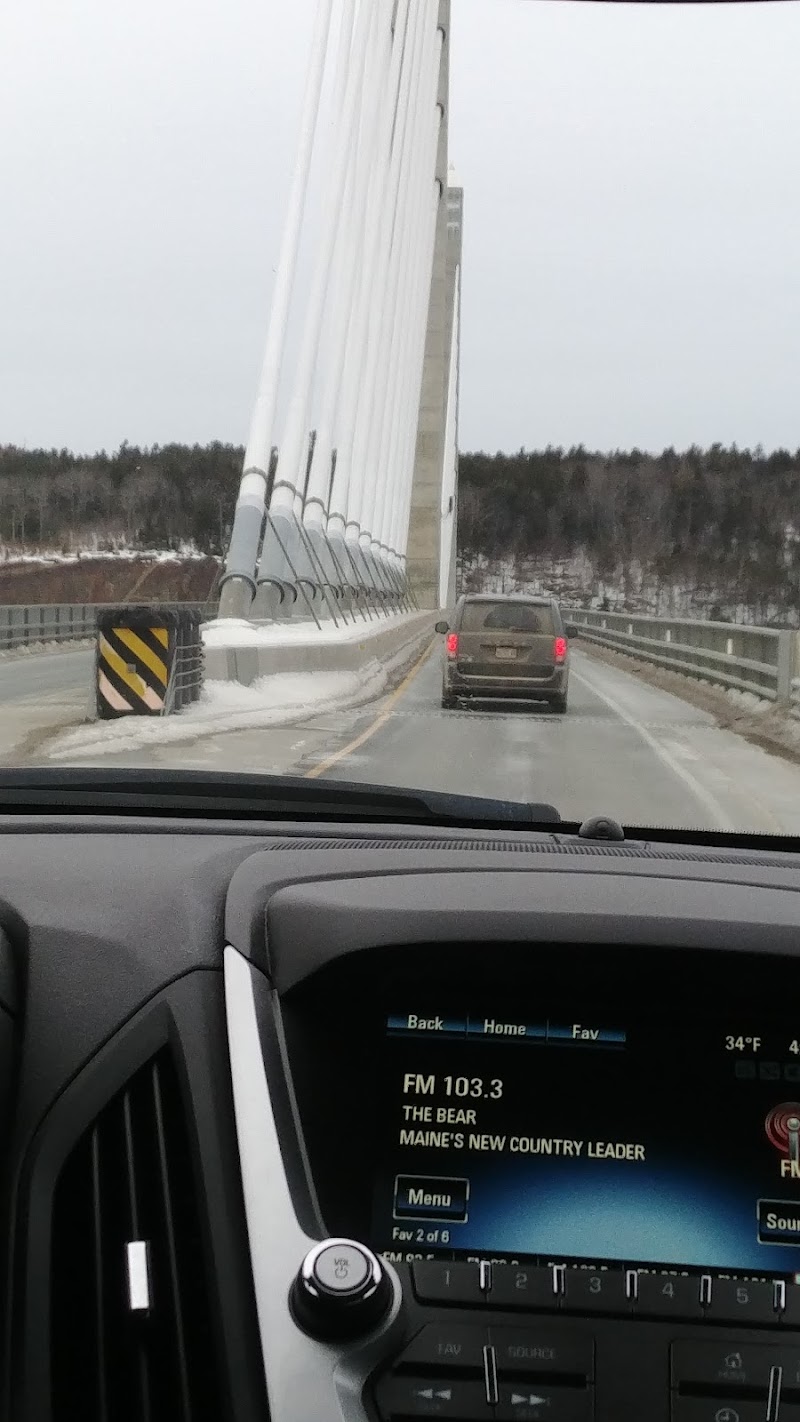 Stockton Springs Bridge crossing the icy road in Acadia National Park, viewed from a vehicle.
