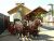 Horse-drawn wagon display near Wall, SD, in Badlands National Park, with a wooden wagon house and railroad crossing sign.