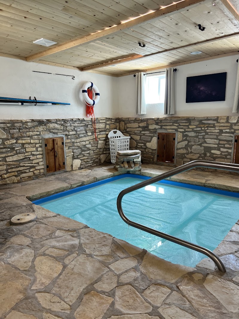 Indoor pool room with stone walls and a wooden ceiling at Big Bend National Park lodging.