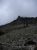 Snyder Lake Campground area in Glacier National Park framed by rocky talus and a clouded ridge.