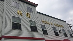 Exterior of a Chinese restaurant building in Acadia National Park, with gold signage on gray siding.
