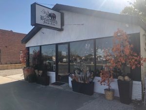 Floral and gift shop storefront in Yellowstone National Park, with large glass windows and autumn plants decorating the entrance.