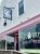 A bright storefront with pink trim and large windows selling ice cream in Acadia National Park.