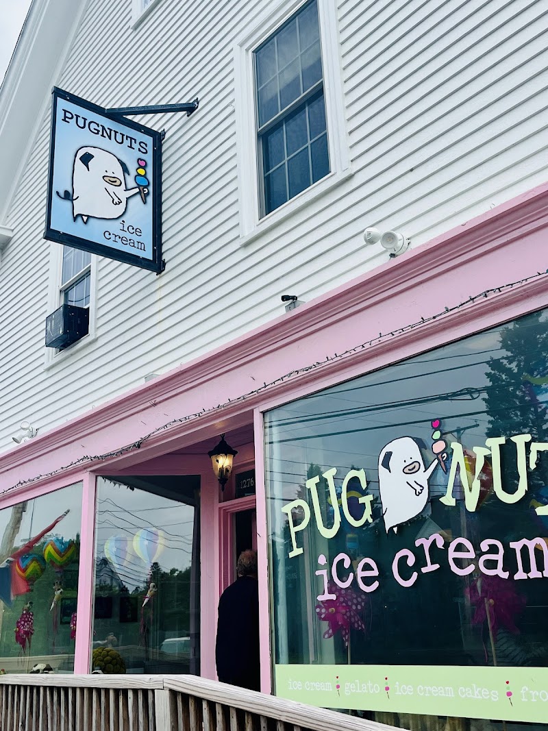 A bright storefront with pink trim and large windows selling ice cream in Acadia National Park.