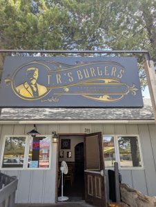 Exterior view of a brick storefront with bold signage and outdoor lighting