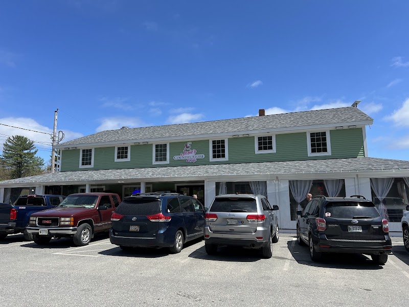 Green, two-story restaurant exterior in Acadia National Park with several parked cars along the storefront.
