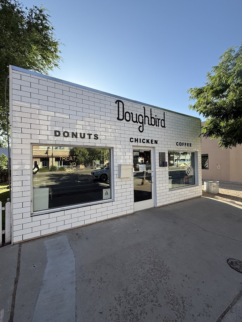 White brick storefront restaurant in Arches National Park with large front windows and simple signage.