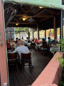 Courtyard dining area inside a cafe at Arches National Park, wood beam ceiling, checkered tables, and patrons eating.