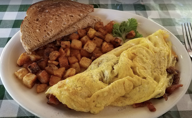 Hearty plate at Arches National Park features a folded omelette, golden hash browns, toasted bread, and a parsley garnish.